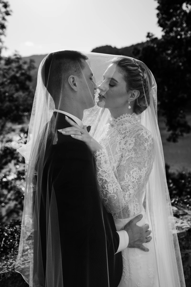 The couple's kiss beneath the veil, black and white