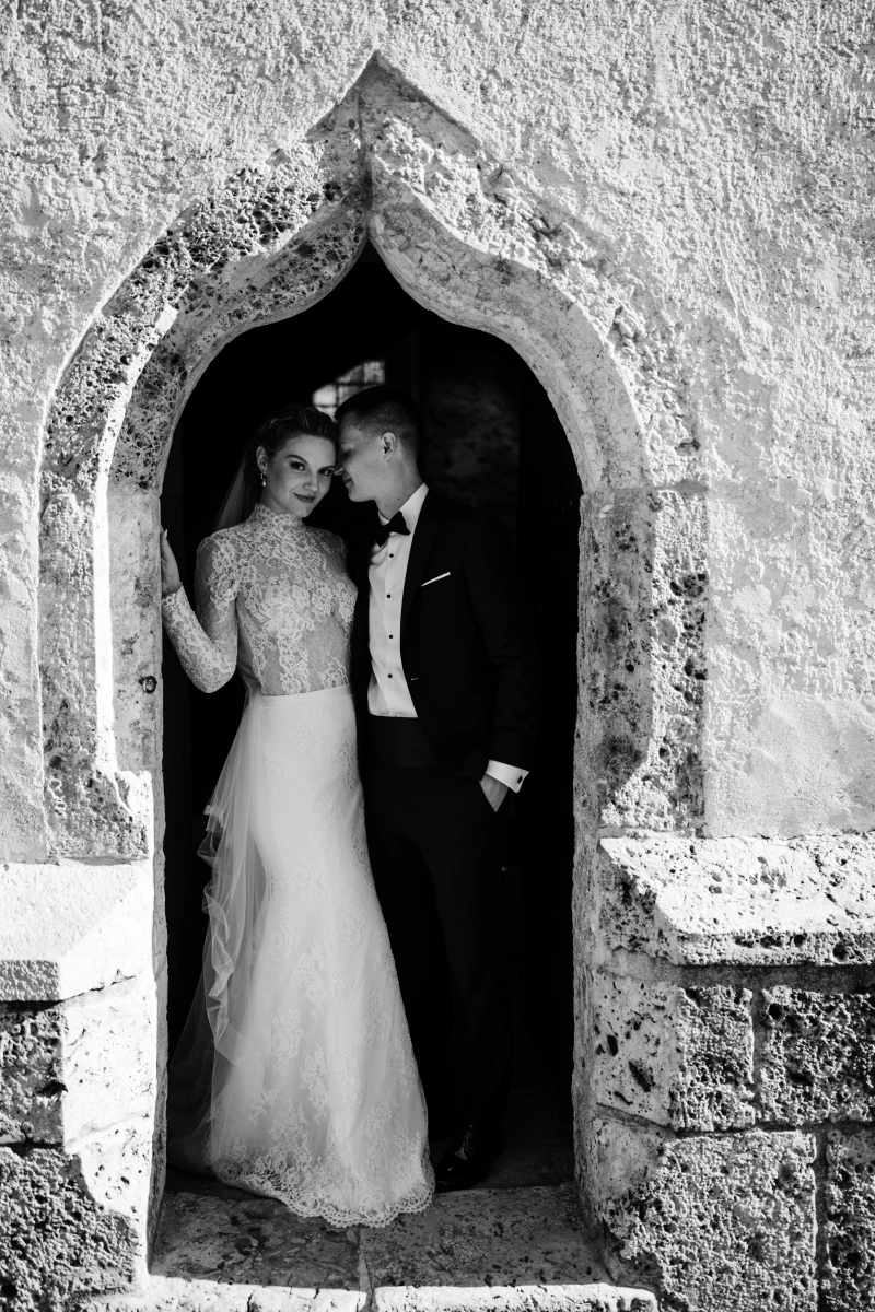Bride and groom in a stone archway