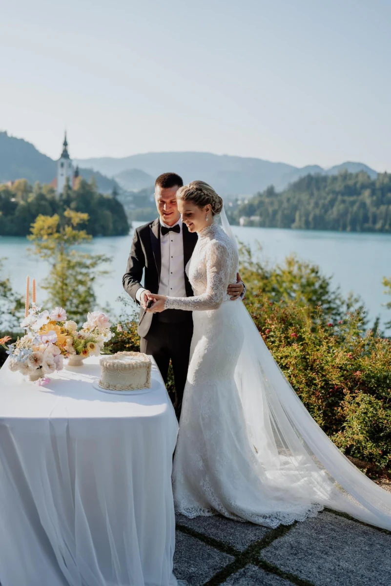 The couple cutting the cake above Lake Bled