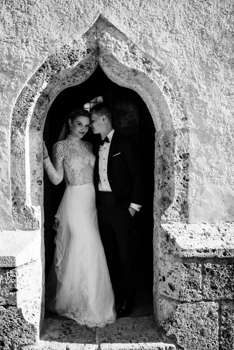 Bride and groom in a stone archway