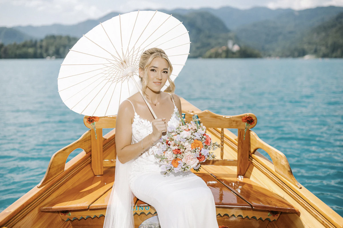 Bride with a parasol on a pletna boat, Lake Bled