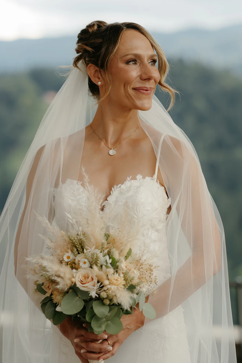 Bride with veil and bouquet in the mountains
