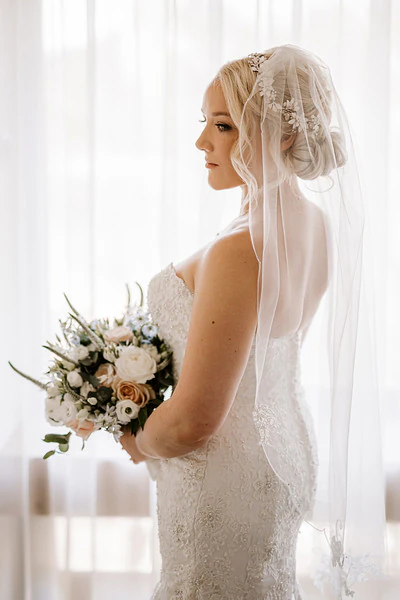 Bride with her bouquet in the window light